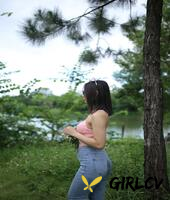 adorable asian girl posing in her sexy top and tight jeans outdoors