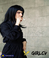 raven-haired woman poses in her sexy black outfit and boots in public