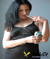 fair skinned female puffs on a smoke while working clear of black lingerie