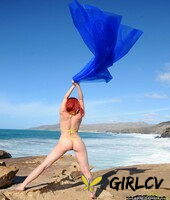 pale redhead piper fawn models in the nude with the ocean behind her26019